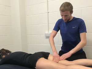 Ollie holding a patients leg during a massage therapy session